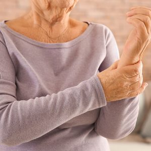 Senior woman suffering from pain in wrist at home