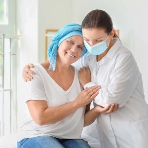 Doctor comforting mature woman after chemotherapy in clinic