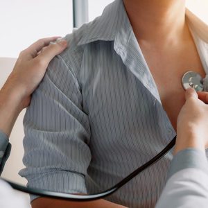 Asian doctor is using a stethoscope listen to the heartbeat of the elderly patient.